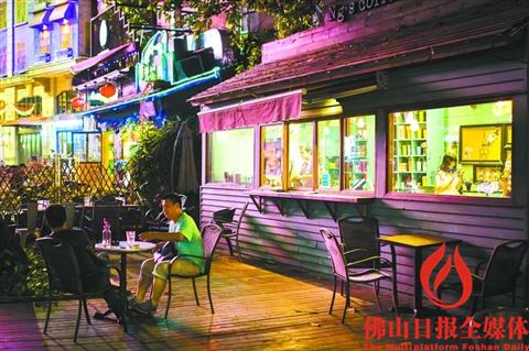 　佛山创意产业园有不少美食，园区内一家茶食店门前两位食客正在用餐。（资料图片）佛山日报见习记者王澍摄